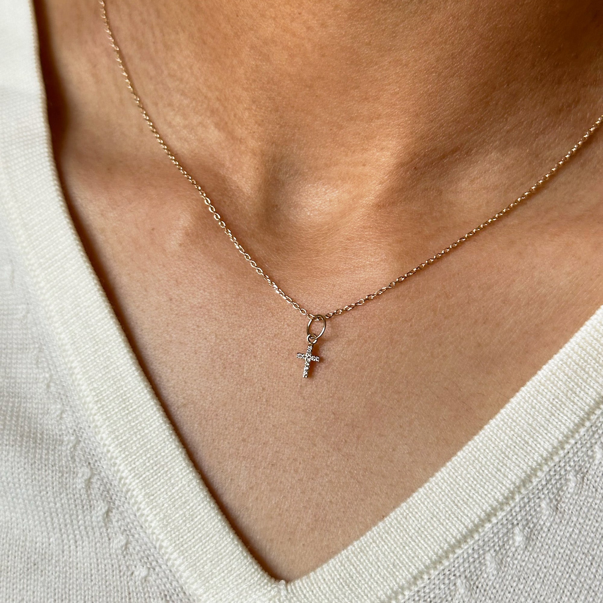 Close up of a woman wearing the Baby Cross Necklace
