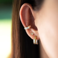 Close up of ear wearing the Baguette Ear Cuff, the Shield Studs, and the Double Prism Rock Huggies