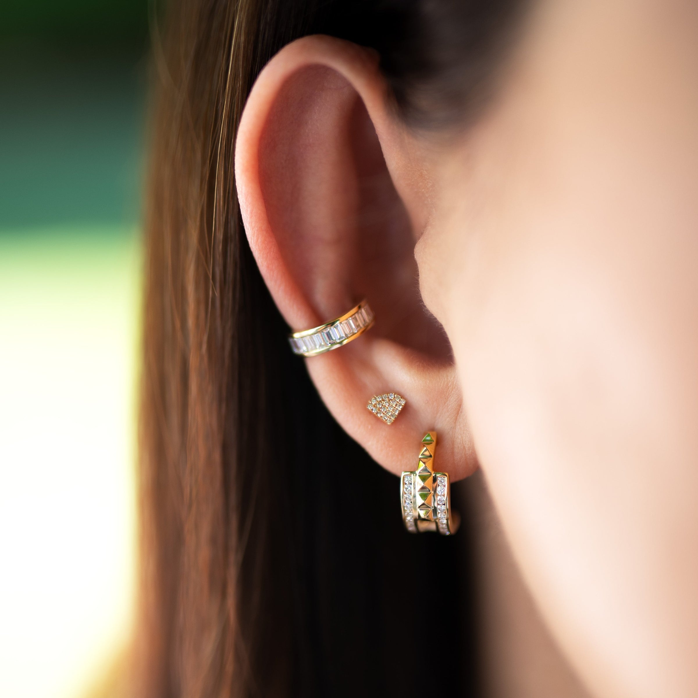 Close up of ear wearing the Baguette Ear Cuff, the Shield Studs, and the Double Prism Rock Huggies