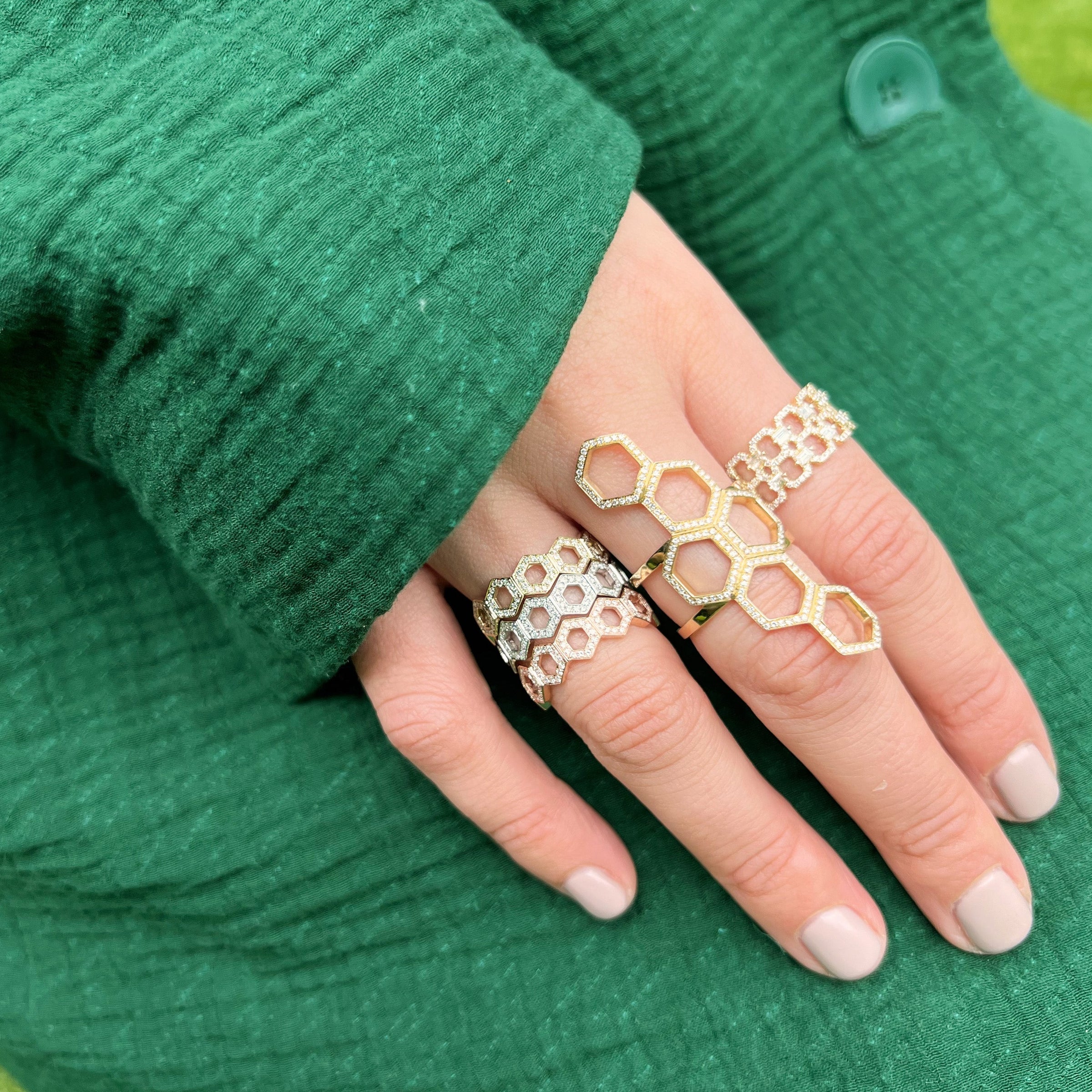 woman wearing the Deco Status Ring, the full stack of the Prism Stackable Rings, and the Queen Bee Ring