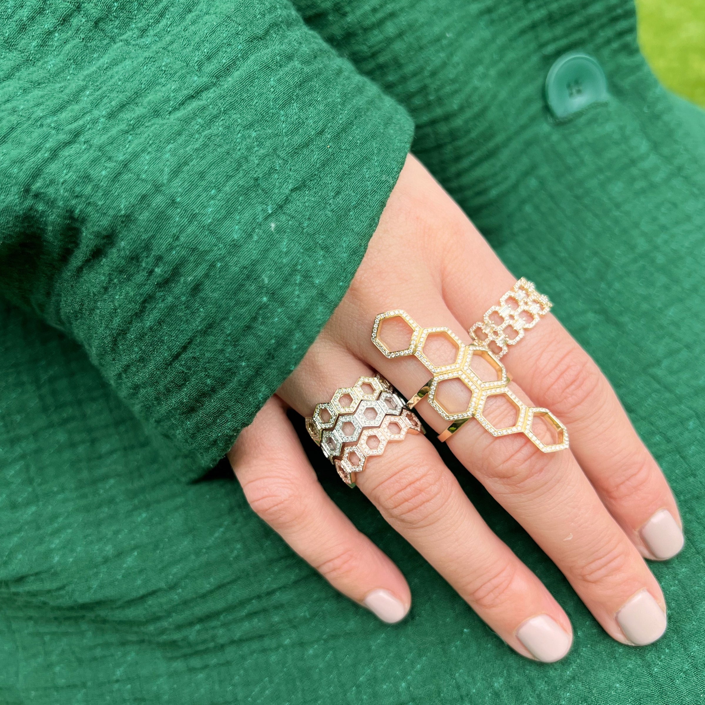 woman wearing the Deco Status Ring, the full stack of the Prism Stackable Rings, and the Queen Bee Ring