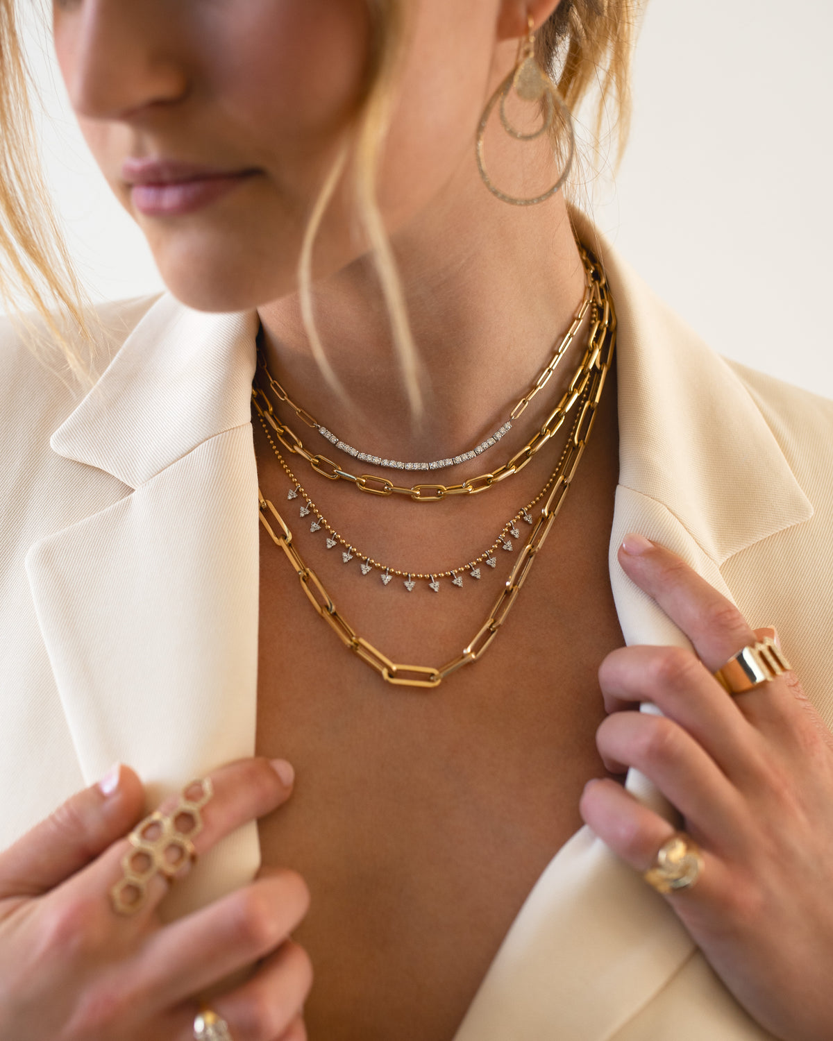 Close up of woman wearing the Diamond Row Necklace, the Barbara Necklace, the Diamond Petal Necklace, and the Paperchain Chain