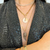 Close up of woman wearing the Diamond Wing Necklace, the Storm Medallion with the X-Large Paperclip Chain with Clasp, and the Gaga Diamond Necklace