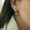 Close Up of woman wearing the Double Bezel Pink Sapphire Heart Drops, and the Chubby Huggies