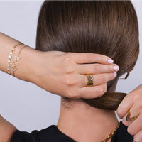The Back of women and she is wearing the Double Chevron Ring, the Diamond Chevron Ring, the 2mm Diamond Stretch Tennis Bracelet, the Diamond Arrow Id Bracelet, the Trillion Cigar Ring, the Open Shield bracelet, and the Shield Bracelet
