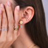 Close-up of an ear with the Eclipse Drops, Open Bar Diamond Ear Cuff, the Diamond Section Stretch Ring, the Prism Stackable Ring, and the Open Bar Diamond Rings.