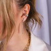 Close-up of a person wearing Illusion Oval Studs, Diamond Serpent Earrings, Baguette Diamond Ear Cuff, and Luxe Diamond Ear Cuff