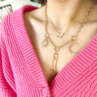 Woman wearing the Kylie Necklace with the Starry Night Pendant, the Sunburst Diamond Pendant and the Large Pink Sapphire Crescent Pendant, and the Butterfly Necklace