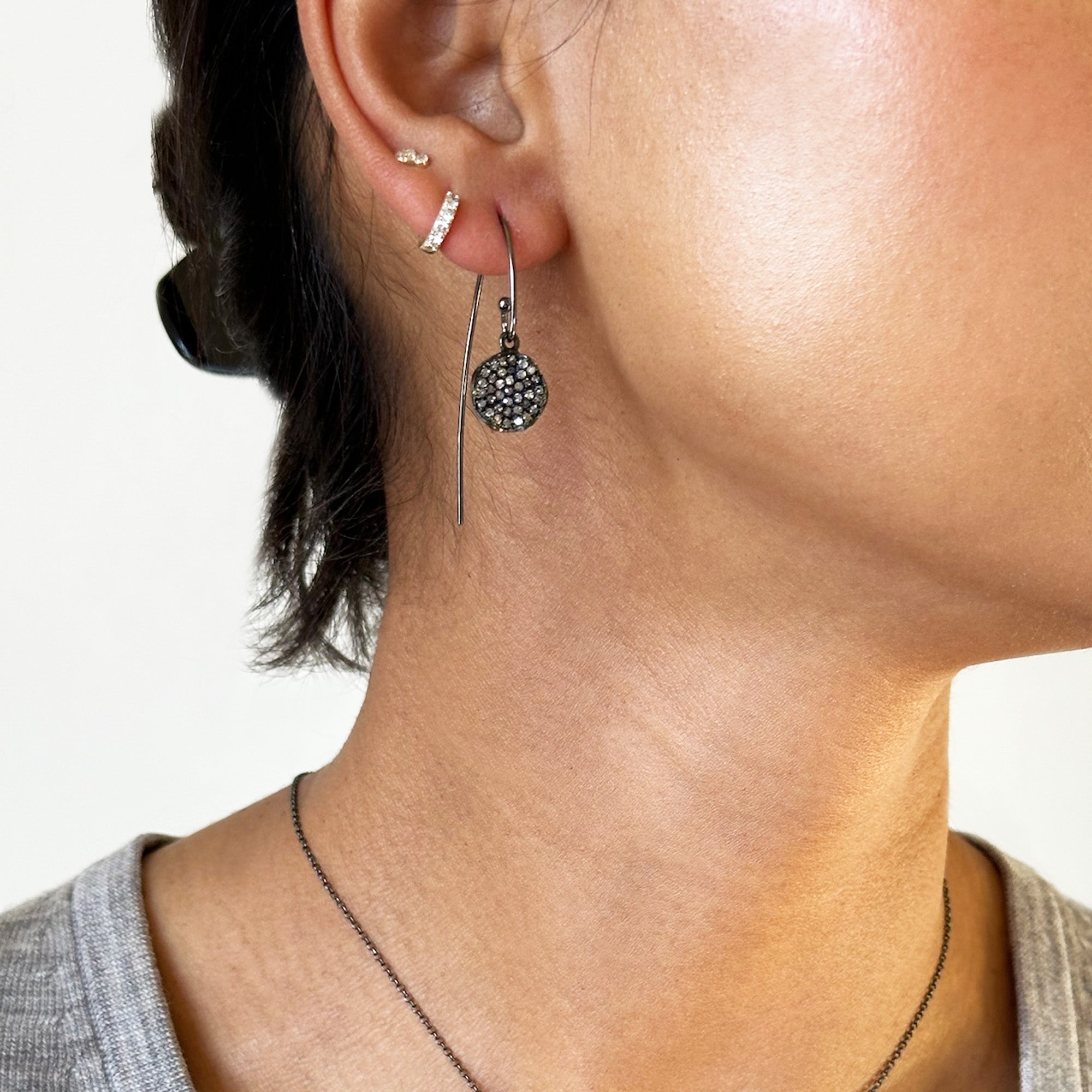 Close-up of a person wearing the Mini Diamond Disc Earrings
