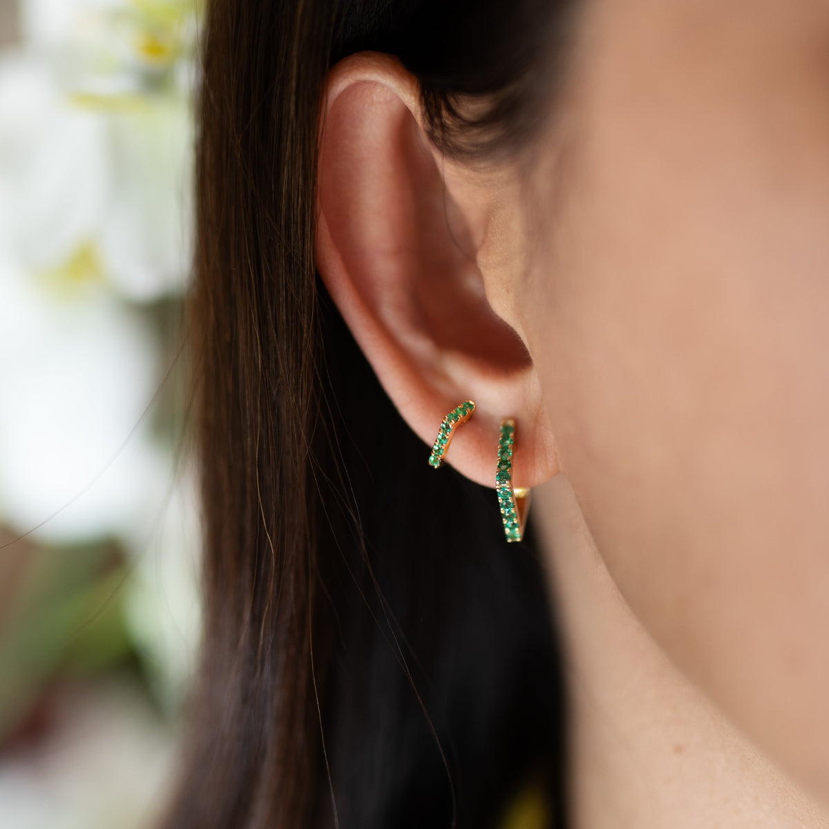 Close up of ear wearing the Mini Emerald Angular Huggies and the Emerald Angular Huggies