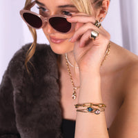 Woman wearing sunglasses, Morganite and London Blue Topaz Liquid Teardrop Bracelets, J Diamond Signet Ring, and Eternity Bracelet