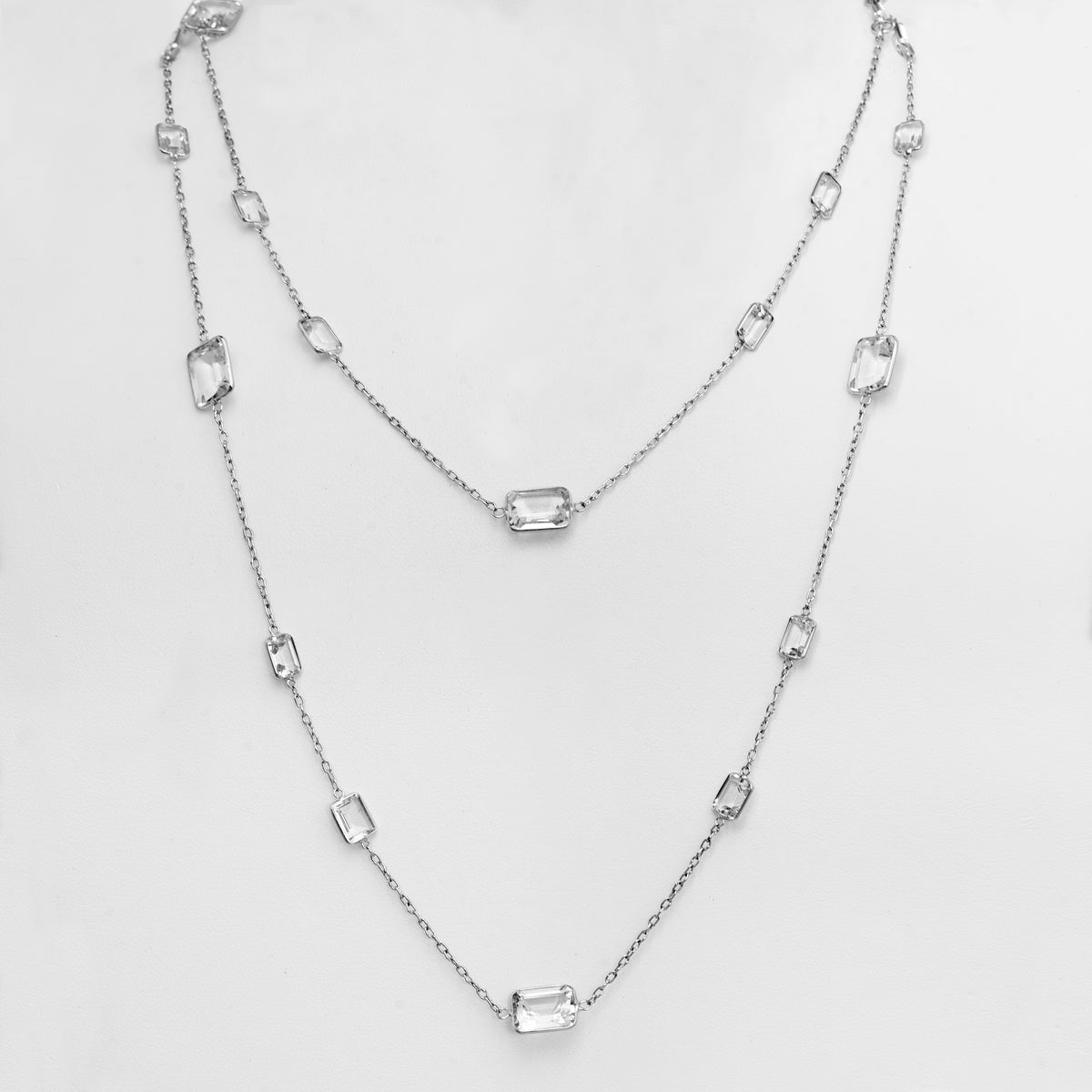 Princess Necklace: a 18K gold long necklace with White Topaz stones throughout the necklace