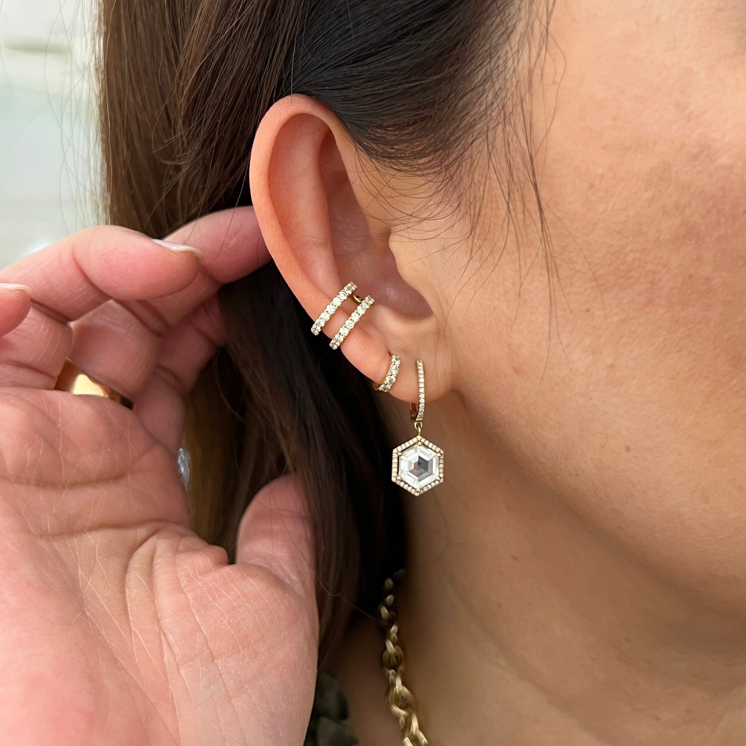 Close up of ear wearing the Prism Hexagon Earrings and the Open Bar Diamond Ear Cuffs