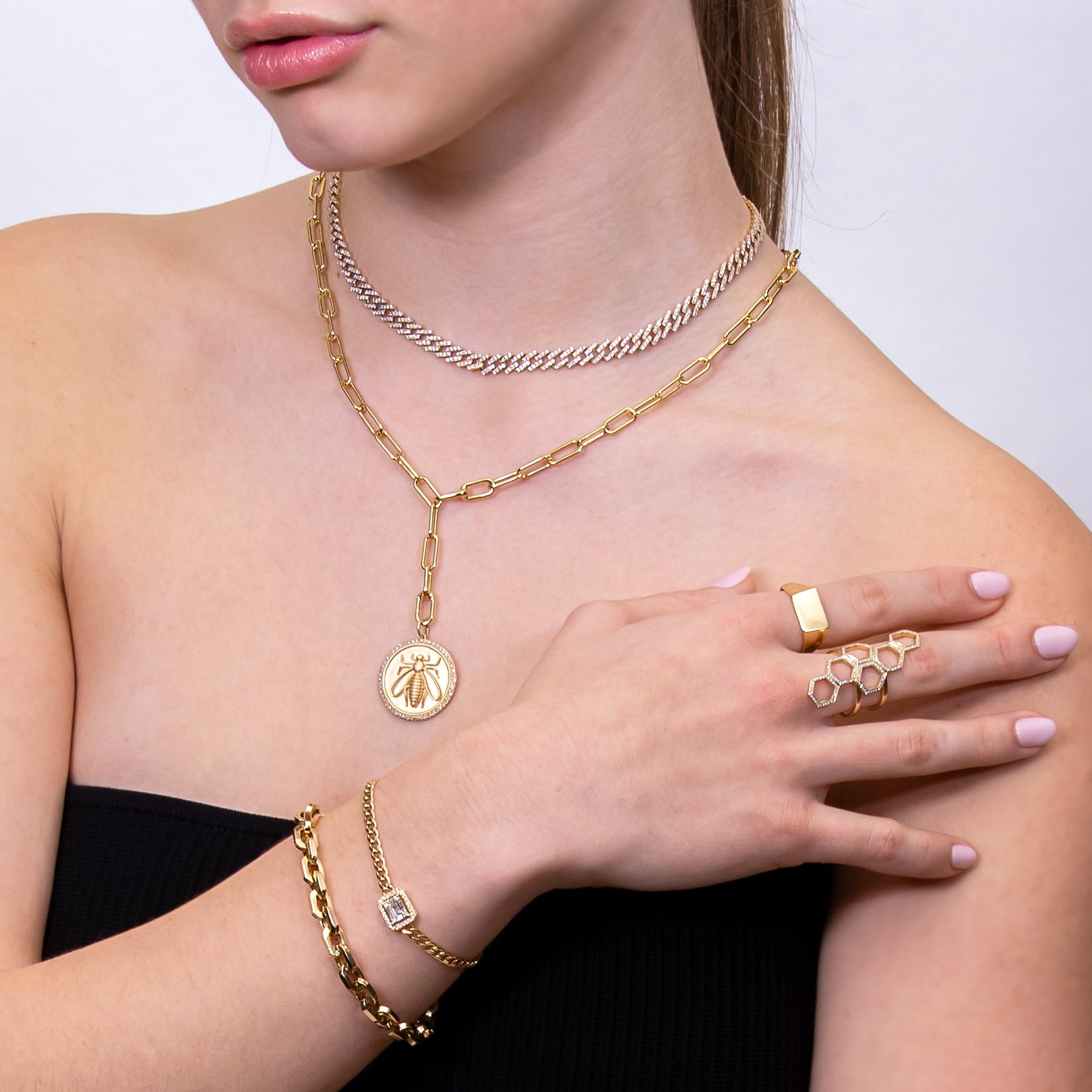 woman wearing the Queen Bee Ring, the Hexagon Diamond Ring, the Halo Illusion Bracelet, the Gaga Necklace, and the Timeless Lariat with the Queen Bee Pendant