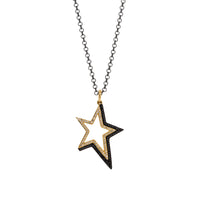 Shadow Hollow Star Necklace: A 14K yellow gold pendant in the shape of a hollow star with black and white diamonds on a chain.