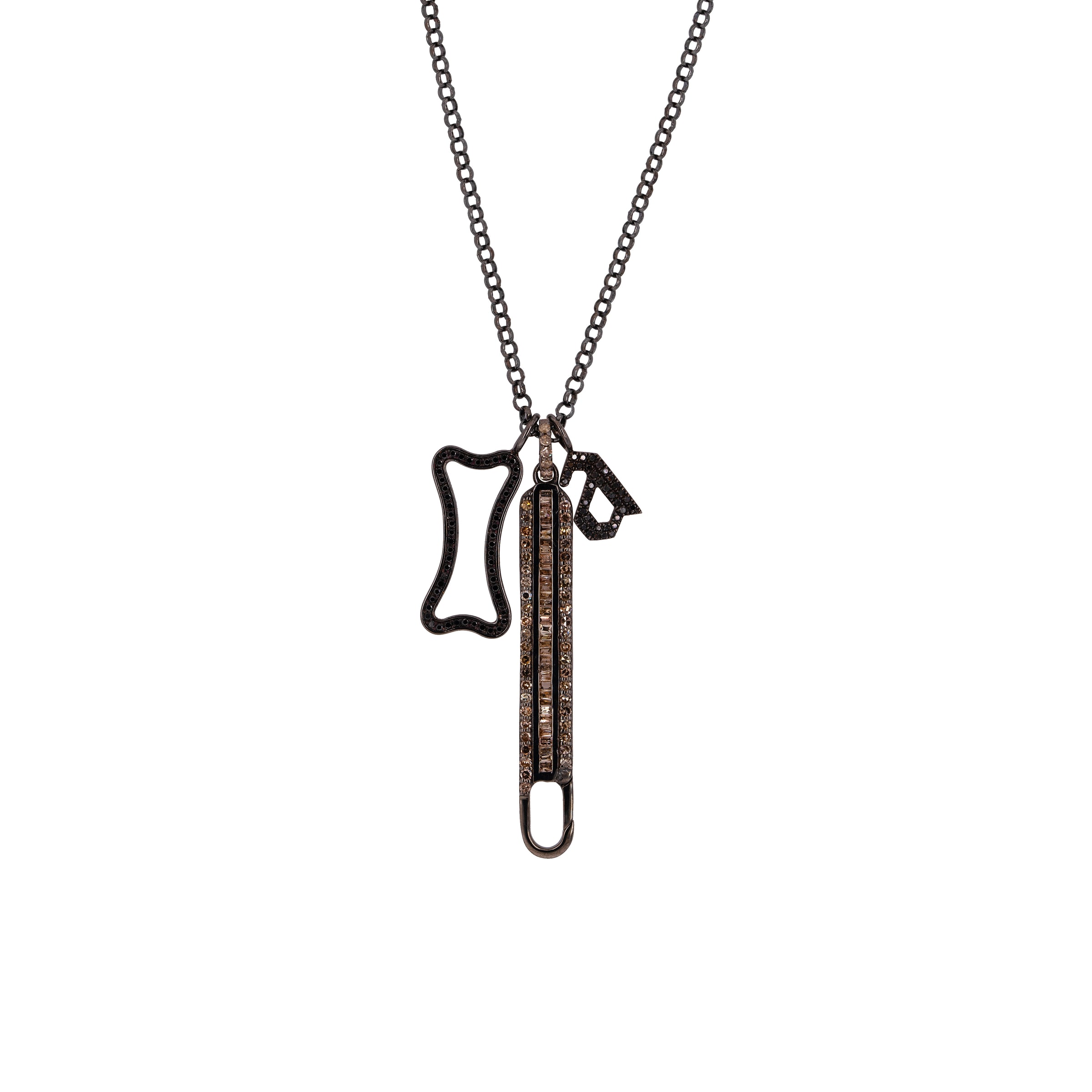A silver charm necklace with a round link chain and three charms, including a Long Baguette Diamond Charm Clasp, a Small Black Diamond Alphabet Pendant, and a Small Hollow Black Diamond Dog Bone Pendant.