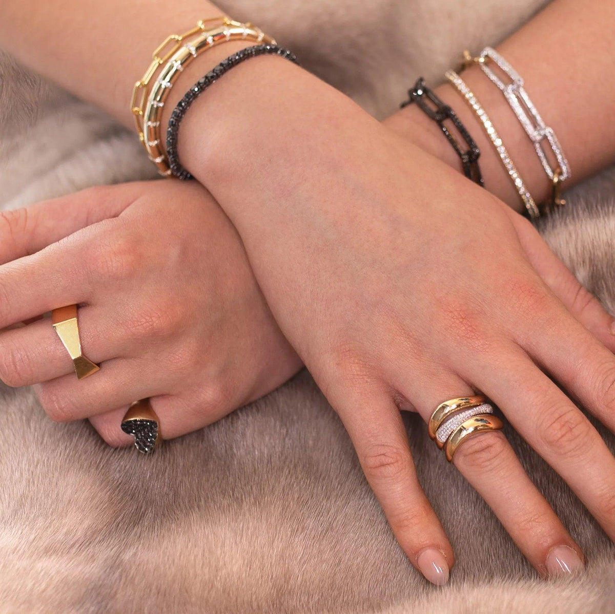 Close-up of hands with the Forever Ring, the Slanted Heart Ring, the Hexagon Diamond Ring