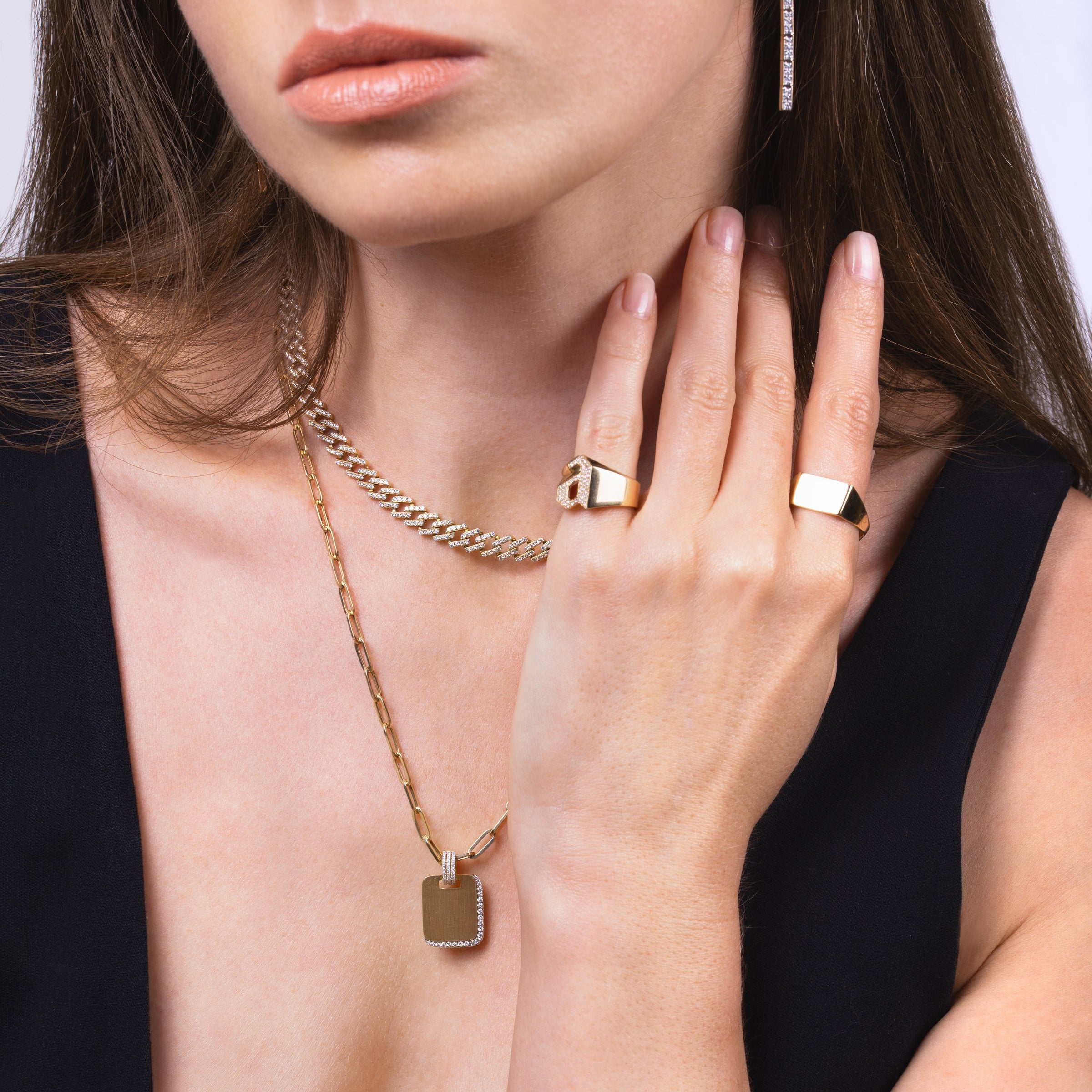 Close-up of a woman wearing the White Diamond Shadow Necklace, the Gaga Diamond Necklace, and the letter "A" Alphabet Signet Ring