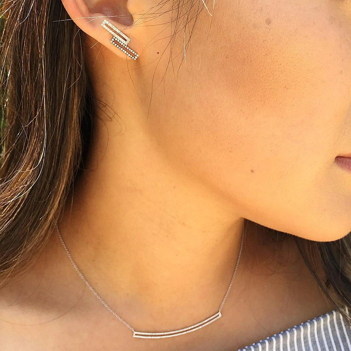 woman wearing the Curved Open Bar Diamond Necklace and the Staggered Open Bar Diamond Studs