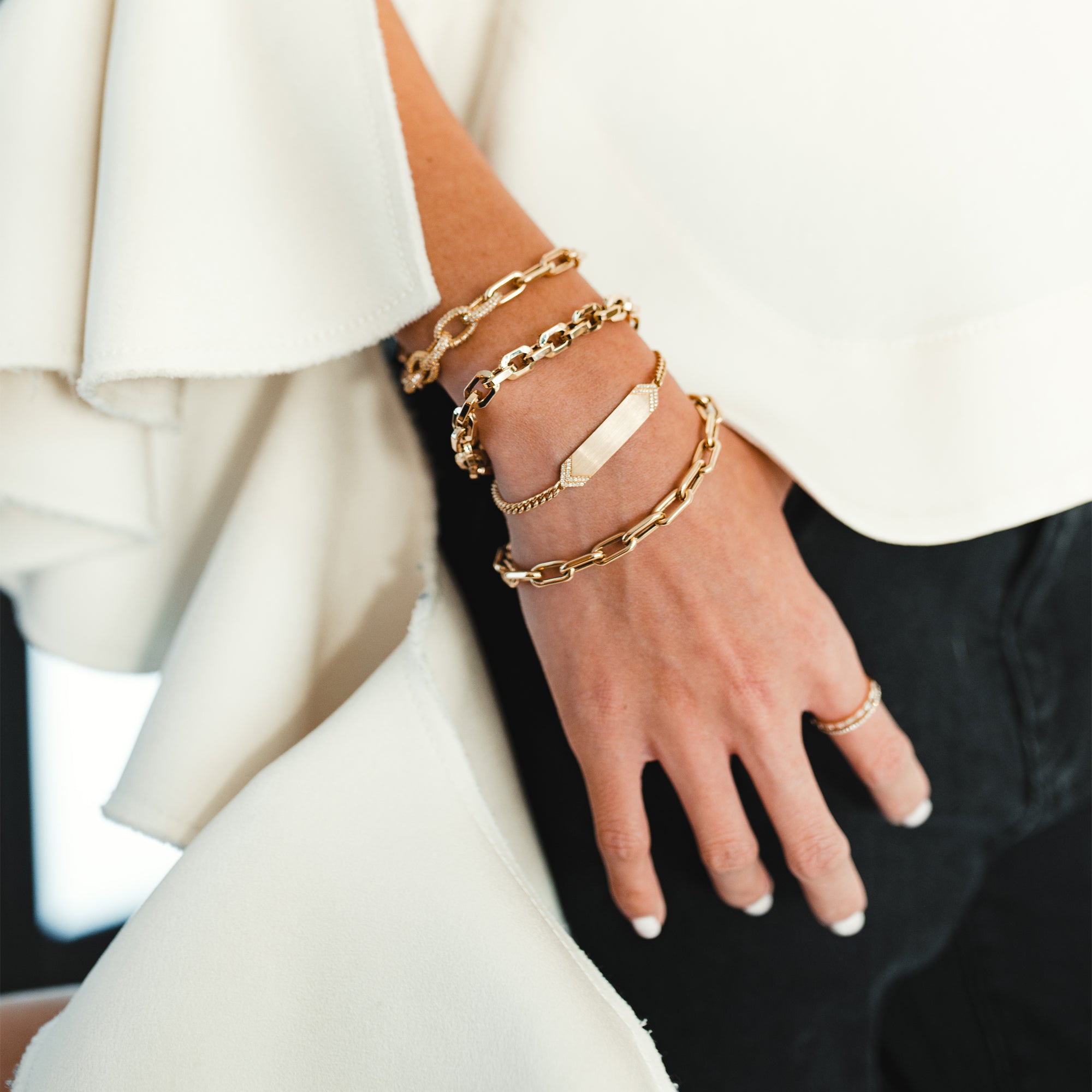 Close up of arm wearing the Diamond Arrow ID Bracelet, and the Granada Bracelet, the Barbara Bracelet