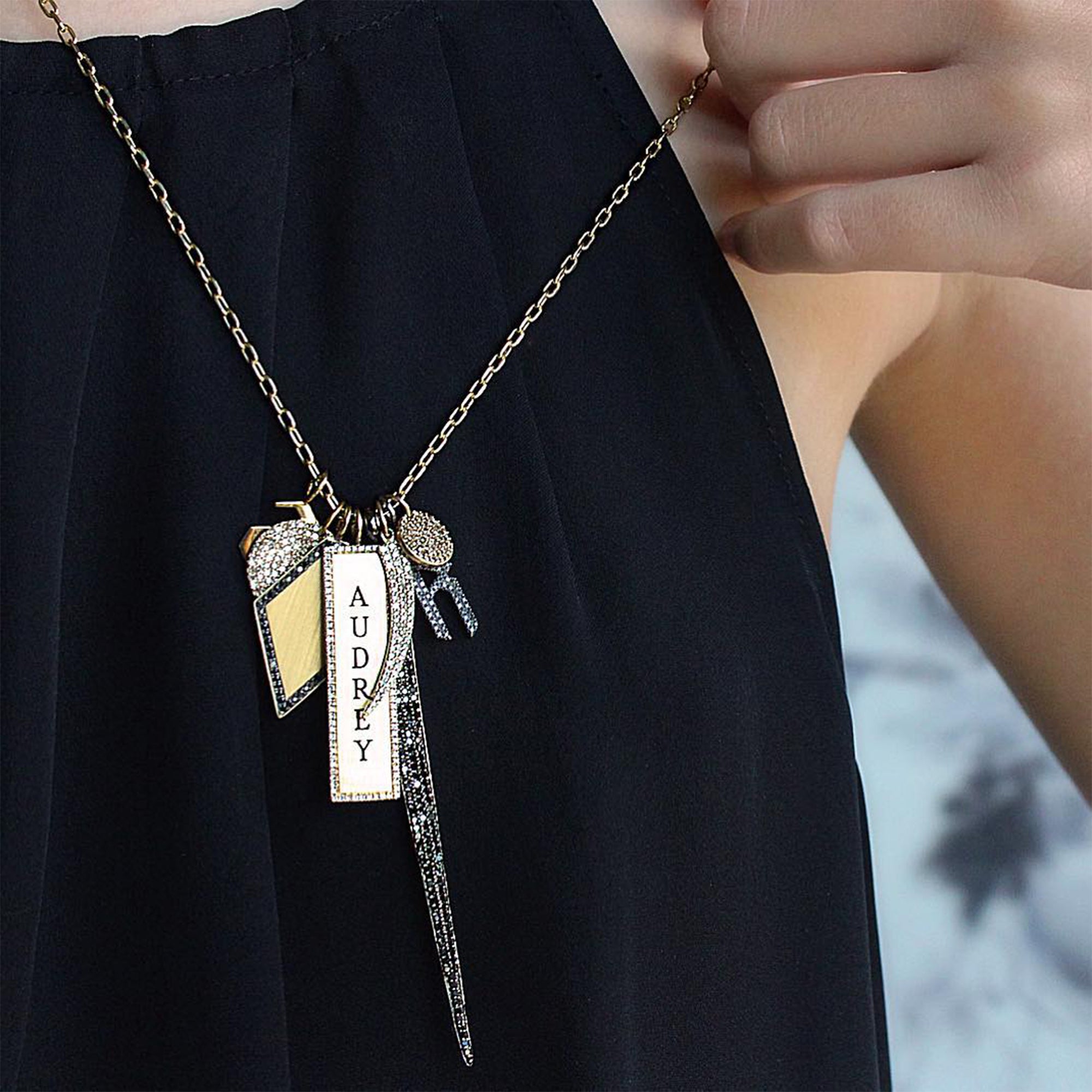 close up of a woman wearing a charm necklace with a Diamond Tusk Pendant, the Diamond Dog Tag, Diamond Shaped Pendant with Black Diamonds