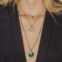 person wearing the Emerald Necklace, the Starburst Diamond & Large Malachite Medallion Necklace, and the Medium Emerald Crescent & Large Diamond Crescent Necklace 