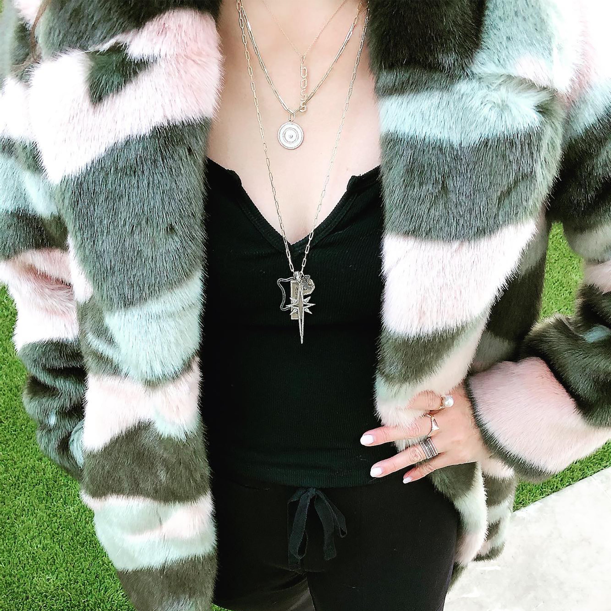 Woman is wearing the Enamel Target Necklace, the Boss Diamond Necklace, and the 'Bridget' Charm Necklace