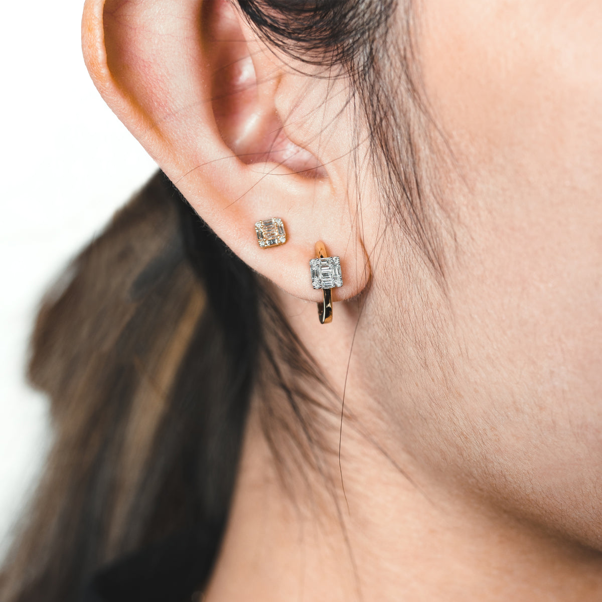 Close up of ear wearing the Floating Illusion Huggies and the Small Illusion Studs