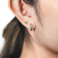 Close up of ear wearing the Floating Illusion Huggies and the Small Illusion Studs