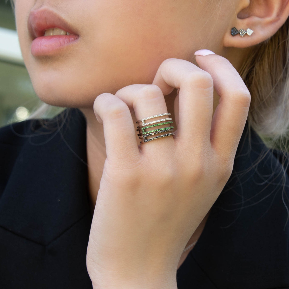 Close up of a hand wearing the Green Garnet Open Bar Ring, Black Diamond Open Bar Ring, and the Diamond Open Bar Ring