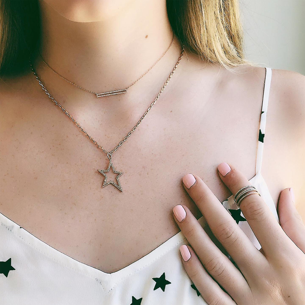 woman wearing the Hollow Diamond Star Necklace and the Open Bar Diamond Necklace