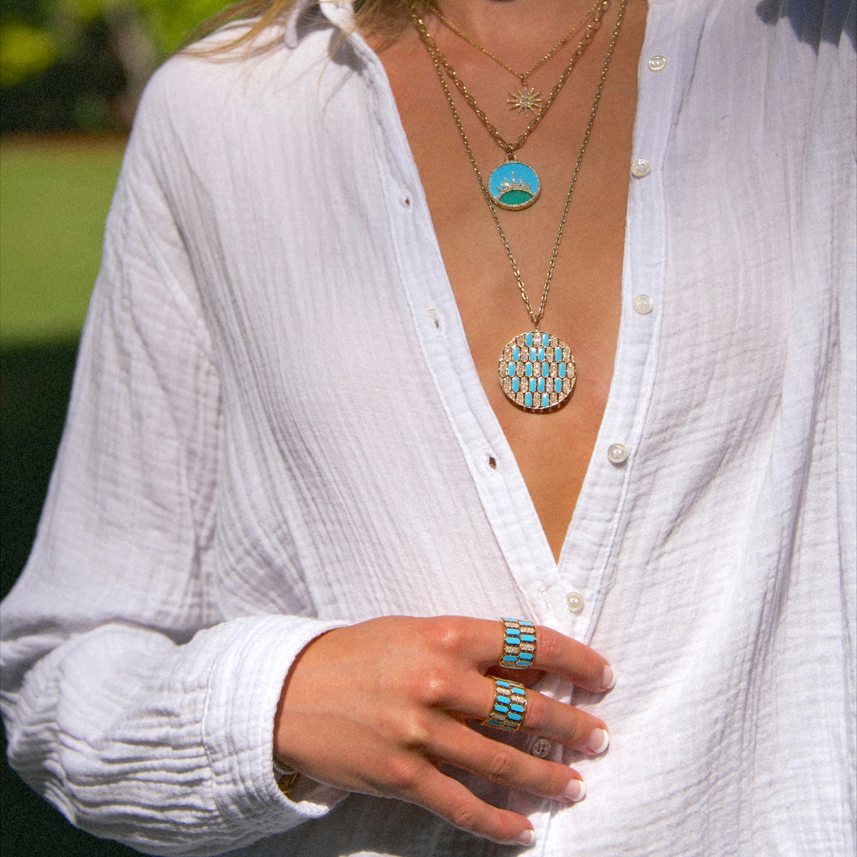 woman wearing the Large Round Turquoise Mosaic Medallion Necklace, the A Better Day Medallion Necklace, the Turquoise Mosaic Infinity Ring, and the Turquoise Mosaic Ring