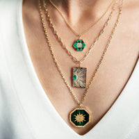 Close up of woman wearing the Malachite Symmetry Necklace, the Emerald Dog Tag Heavenly Dog Tag Necklace, and the Malachite Octagon Medallion Necklace
