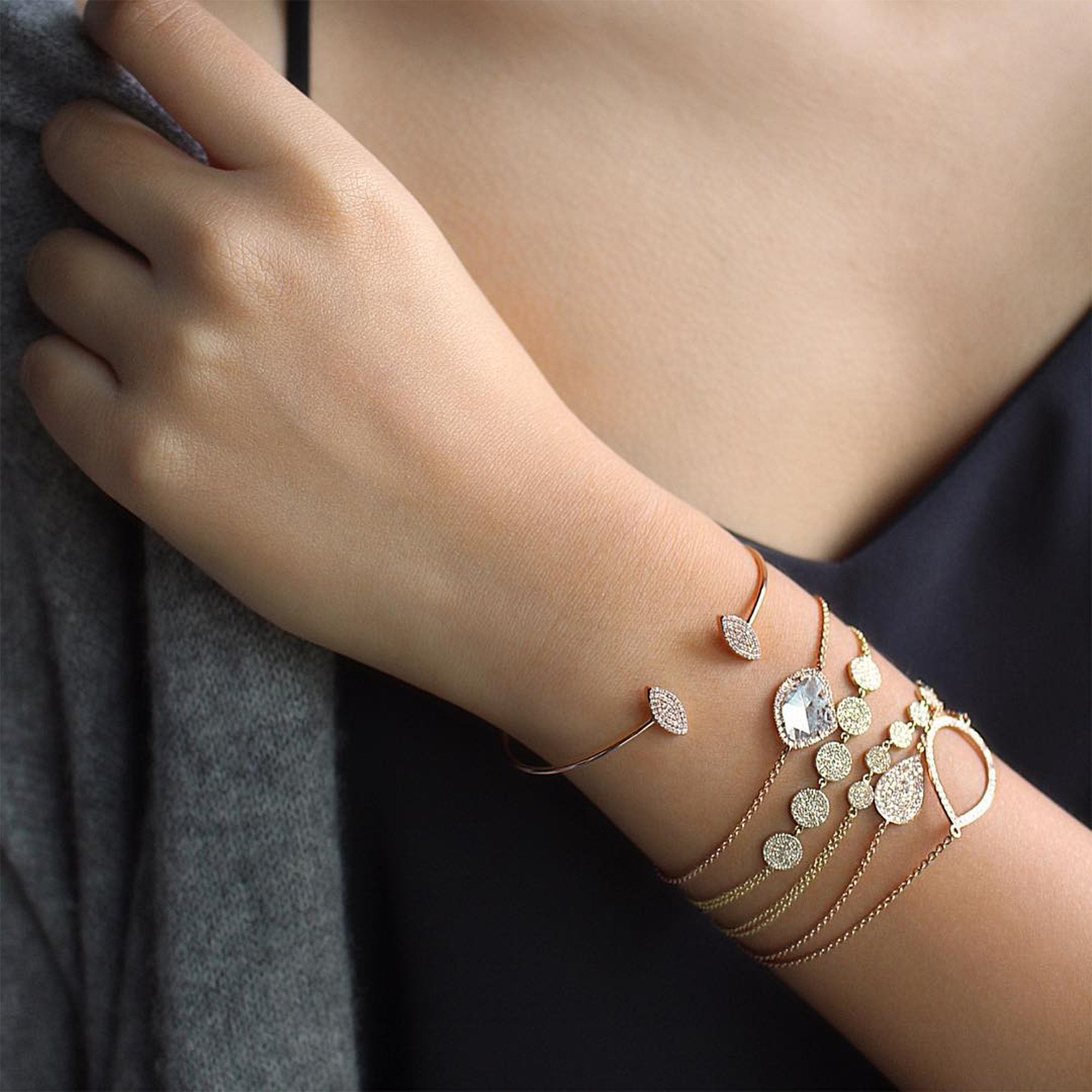 Close up of an arm wearing the Pave Marquis Diamond Bracelet, the 7 Dot Diamond Bracelet, the 5 Dot Diamond Bracelet, the Mini Pave Diamond Teardrop Bracelet, and the Diamond Teardrop Bracelet