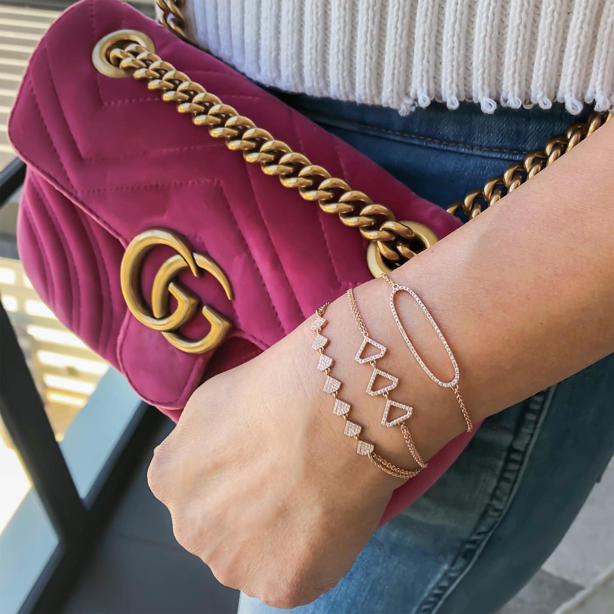 Arm wearing the Shield Bracelet, the Open Shield Bracelet, and the Diamond Oval Bracelet