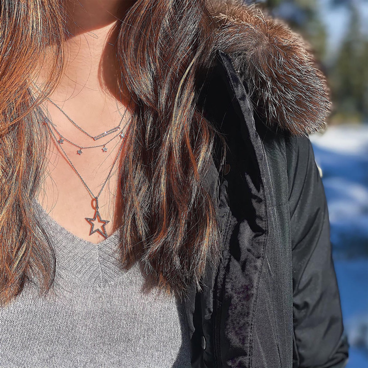 woman is wearing the Silver Hollow Diamond Star Necklace, and the Open Bar Diamond Necklace