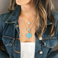 Woman wearing the Turquoise Halo Medallion Necklace, the Turquoise Shooting Star Necklace, and the Turquoise Another Dawn Necklace