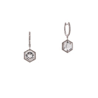 White Gold Prism Hexagon Earrings: A pair of 14K gold earrings featuring drops of a white topaz gemstone in a hexagonal setting with smaller diamonds around it, attached to hinged huggies
