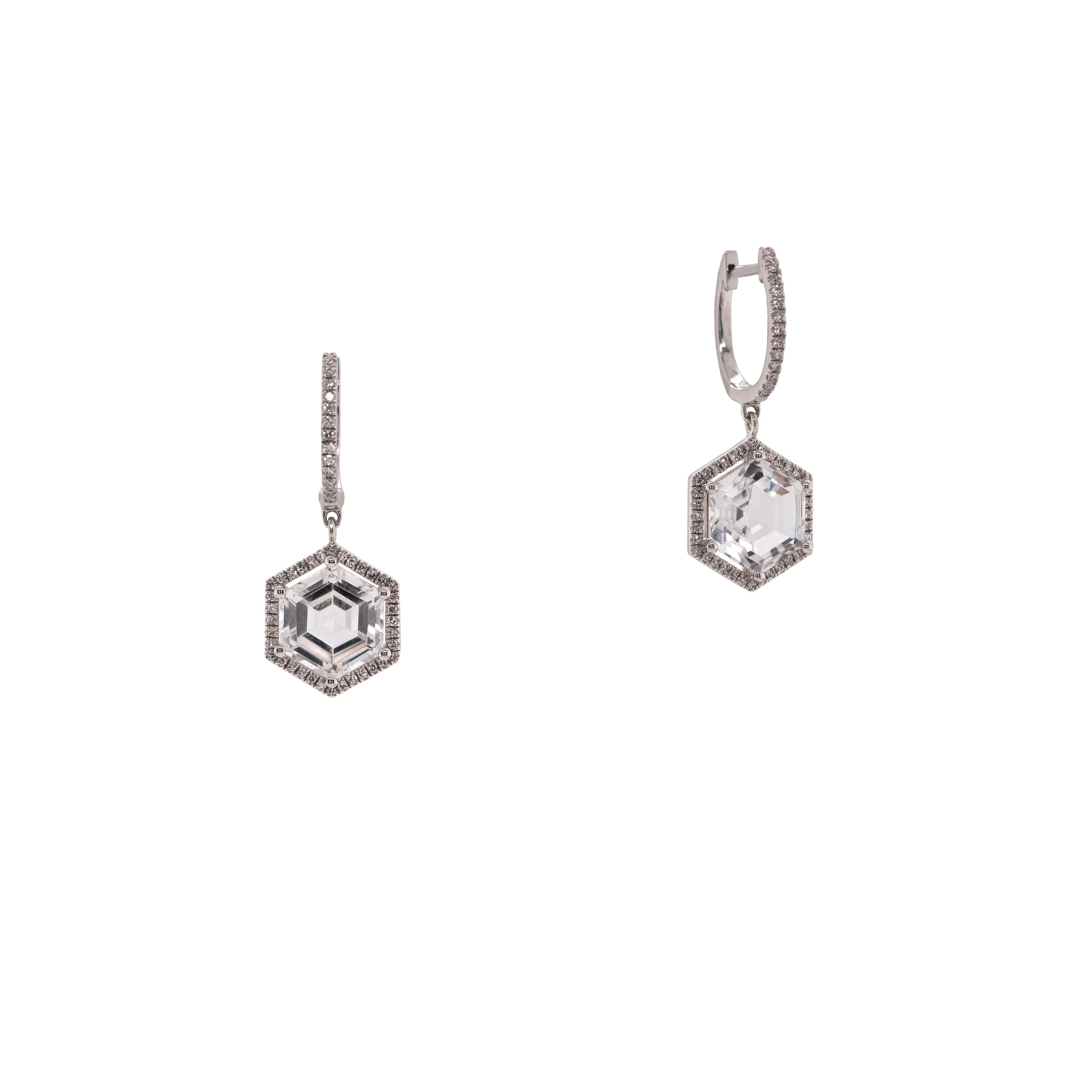 White Gold Prism Hexagon Earrings: A pair of 14K gold earrings featuring drops of a white topaz gemstone in a hexagonal setting with smaller diamonds around it, attached to hinged huggies
