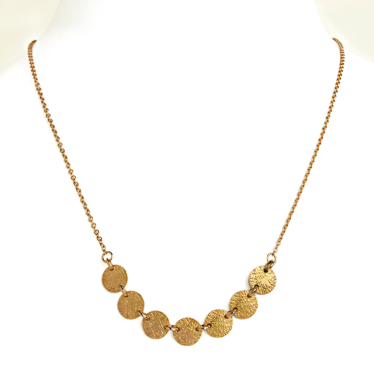 Yellow Gold 7-Dot Necklace: A 14K gold necklace with a series of round charms connected by a chain.