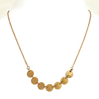 Yellow Gold 7-Dot Necklace: A 14K gold necklace with a series of round charms connected by a chain.