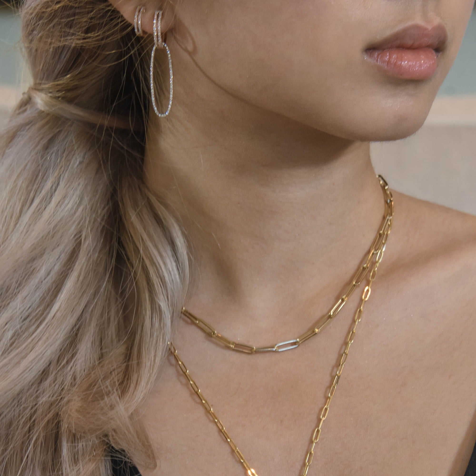 Woman wearing the Yellow Gold Open Bar Diamond Huggies w/ Reversible White & Black Diamond Oval Extensions, the Mini Open Bar Diamond Huggies, and the Timeless Choker