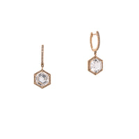 Yellow Gold Prism Hexagon Earrings: A pair of 14K gold earrings featuring drops of a white topaz gemstone in a hexagonal setting with smaller diamonds around it, attached to hinged huggies