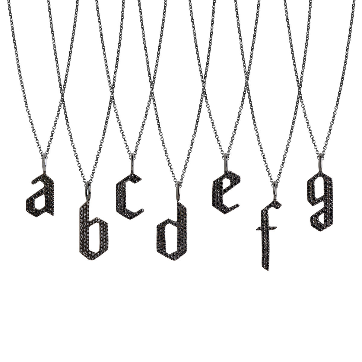 a - g Small Black Diamond Alphabet Necklaces: A series of oxidized sterling silver necklaces with black diamond letters, adjustable in length and featuring a lobster clasp fastening.