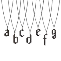a - g Small Black Diamond Alphabet Necklaces: A series of oxidized sterling silver necklaces with black diamond letters, adjustable in length and featuring a lobster clasp fastening.
